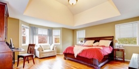 Large master bedroom interior with green alls and hardwood floor